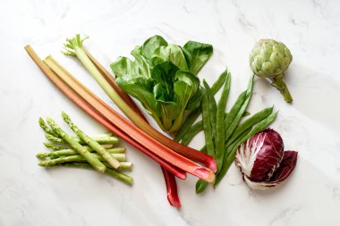 Salata ve sebzeler beyaz mermer masa, üst manzara, sağlıklı vejetaryen gıda konsepti