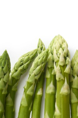 Beyaz arka planda izole edilmiş taze yeşil kuşkonmaz. Düz uzanıyordu vejetaryen yiyeceklerle Sağlıklı yiyecekler yukarıdan