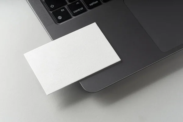灰色背景下的现代名片模型模板 在笔记本电脑旁边放着一张卡片的顶视图平铺 品牌设计 广告及设计的模型设计 — 图库照片