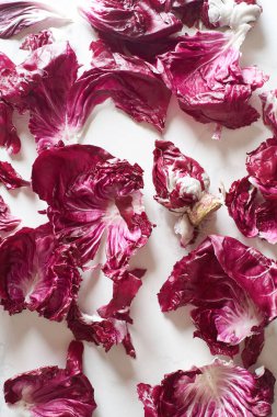 Fresh radicchio salad leaves arranged on marble cooking table. View from above