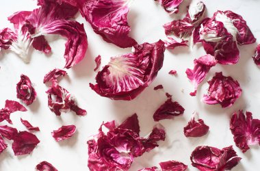 Fresh radicchio salad leaves arranged on marble cooking table. View from above