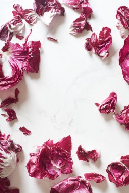 Fresh radicchio salad leaves arranged on marble cooking table. View from above with copy space at the cente