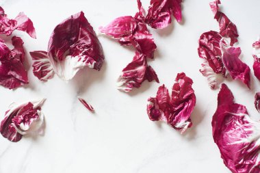 Fresh radicchio salad leaves arranged on marble cooking table. View from above