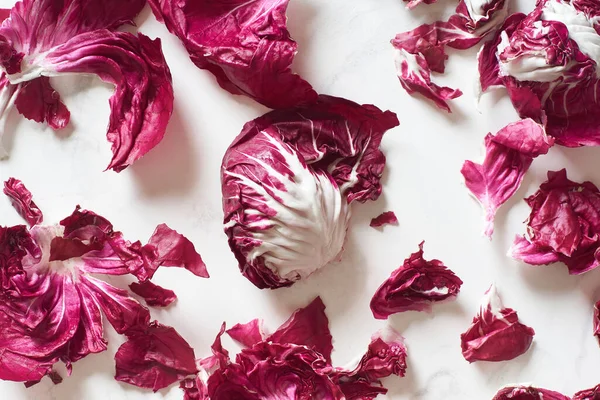 Fresh radicchio salad leaves arranged on marble cooking table. View from above