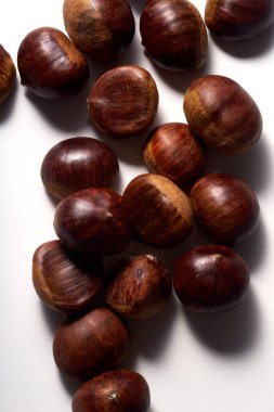 Top view of raw uncooked chestnuts on white background