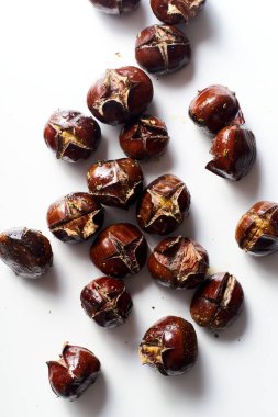 Flat lay with roasted chestnuts on white background