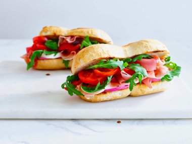 Tasty sandwich with ham, mozarella and fresh vegetables. Simple lunch concept