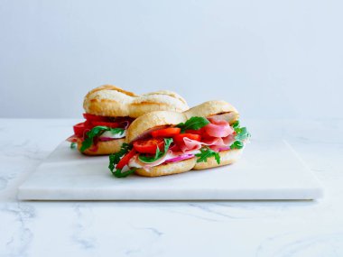 Tasty sandwich with ham, mozarella and fresh vegetables. Simple lunch concept. Copy space