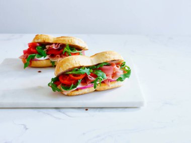 Tasty sandwich with ham, mozarella and fresh vegetables. Simple lunch concept. Copy space