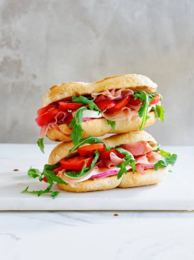 Tasty sandwich with ham, mozarella and fresh vegetables. Simple lunch concept. Copy space