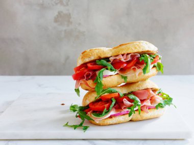 Tasty sandwich with ham, mozarella and fresh vegetables. Simple lunch concept. Copy space