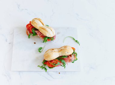 Flat lay with tasty sandwiches with ham, mozarella and fresh vegetables. Simple lunch concept. Text space