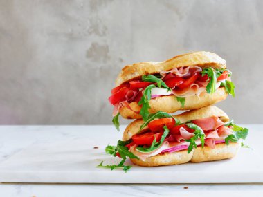 Tasty sandwich with ham, mozarella and fresh vegetables. Simple lunch concept. Copy space