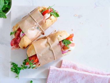 Flat lay with tasty sandwiches with ham, mozarella and fresh vegetables. Simple lunch concept. Text space