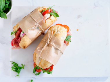 Flat lay with tasty sandwiches with ham, mozarella and fresh vegetables. Simple lunch concept. Text space