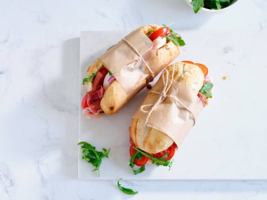 Flat lay with tasty sandwiches with ham, mozarella and fresh vegetables. Simple lunch concept. Text space