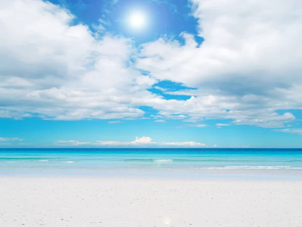 白色的沙滩和蓝色天空与太阳 — 图库照片