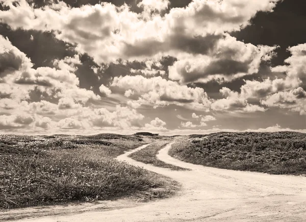 Schotterpiste und Wolken im Sepia-Ton — Stockfoto