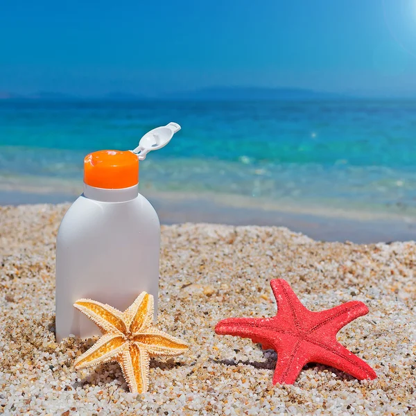 Suntan lotion and seastars — Stock Photo, Image