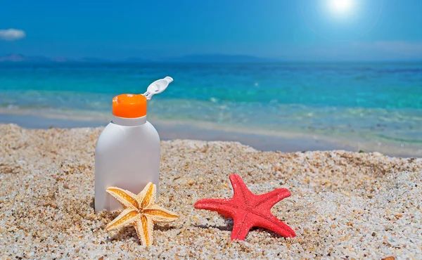 Suntan lotion and seastars — Stock Photo, Image