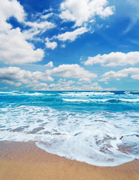 Schuimige shore en schilderachtige wolken — Stockfoto