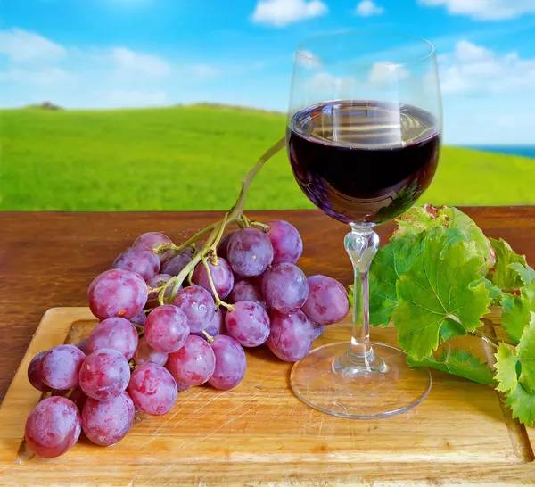 Grape and wine on a chopping board — Stock Photo, Image