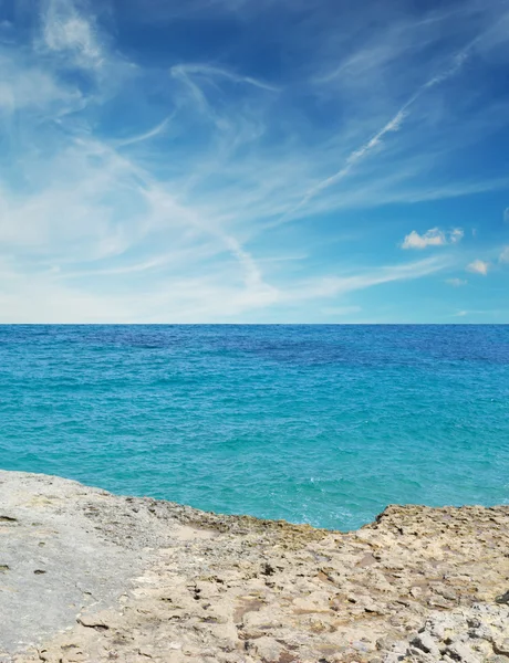 Moln över en stenig strand — Stockfoto