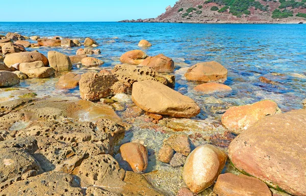 Bruine stenen en blauw water — Stockfoto