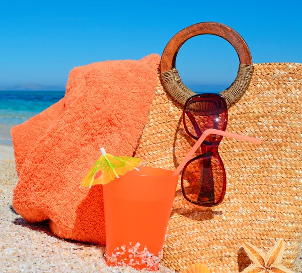 Bebida y bolsa de paja en la playa — Foto de Stock