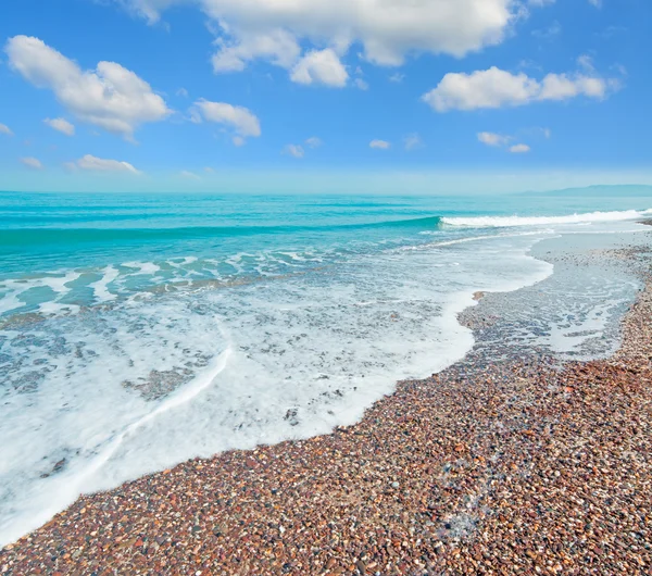 Pebbles, waves  and clouds — Stock Photo, Image