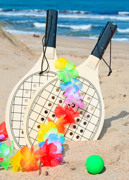 Rackets and necklace on the shore — Stock Photo, Image