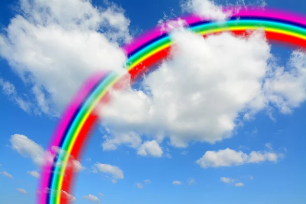 Nubes blancas y cielo azul con un colorido arco iris — Foto de Stock