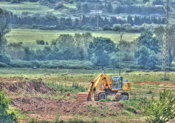 Bulldozer solo en un campo verde — Foto de Stock