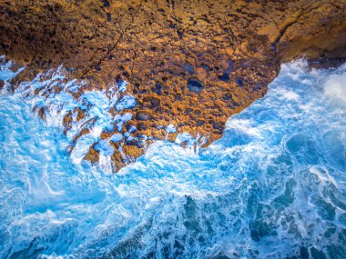 Dalgalı köpük adn kayalık kıyıdan görüldü. Sardunya, İtalya