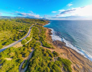 Alghero sahilindeki kaya ve mavi deniz yukarıdan görülüyor. Sardunya, İtalya