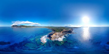 Parlayan güneşin altındaki Porto Ferro Körfezi 'nin havadan görüntüsü. Sardunya, İtalya