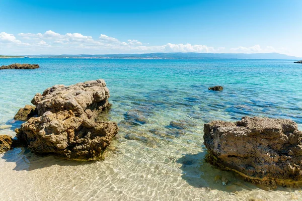 Alghero sahilinde kayalar ve mavi deniz. Sardunya, İtalya