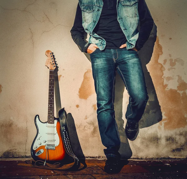 Vista Frontal Hombre Una Guitarra Apoyados Una Pared Grunge —  Fotos de Stock