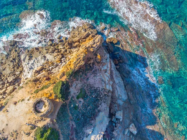 Turkuaz suyla çevrili Porto Ferro kulesinin hava manzarası. Sardunya, İtalya