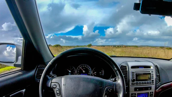 Interior view of a car driving in the countryside on a cloudy day