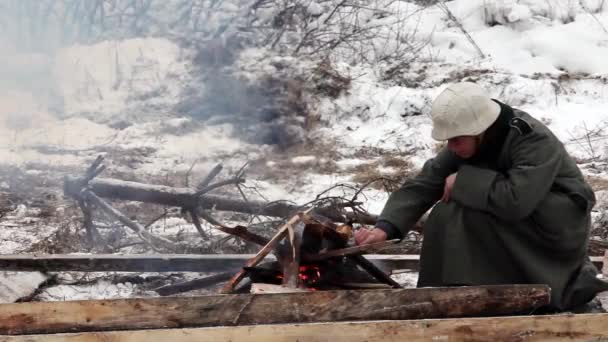 Voják rozněcuje oheň — Stock video