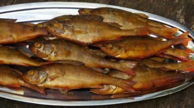 Büyük bir tabakta tütsülenmiş iştah açıcı altın levrek.