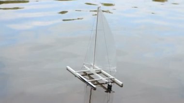 oyuncak küçük yelkenli katamaran dalgalarda sallanıyor