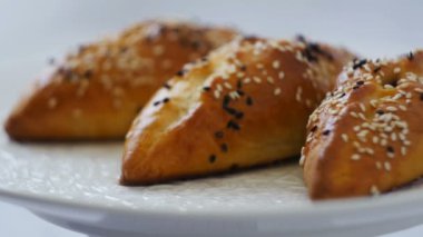 appetizing ruddy cakes sprinkled with sesame seeds close-up parallax