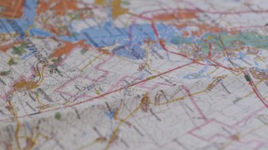 paper topographic map and magnetic compass close-up