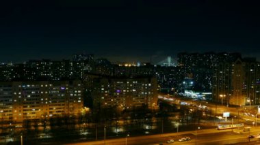 Gece büyük şehir hava manzarası, pencerelerdeki ışık arabaların hareketlerini bulanıklaştırıyor.