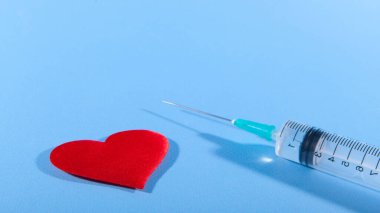 Mutsuz aşkın sembolü olarak kırmızı kalp ve şırınga