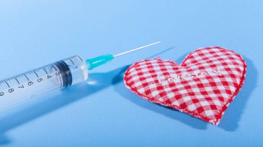 Mutsuz aşkın sembolü olarak kırmızı kalp ve şırınga