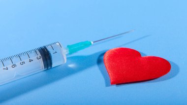 Mutsuz aşkın sembolü olarak kırmızı kalp ve şırınga