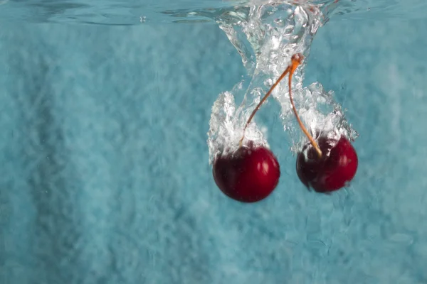 Cherries splashing in wate — Stock Photo, Image